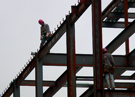 Closeup of workmen on girders building the Kent Hall addition