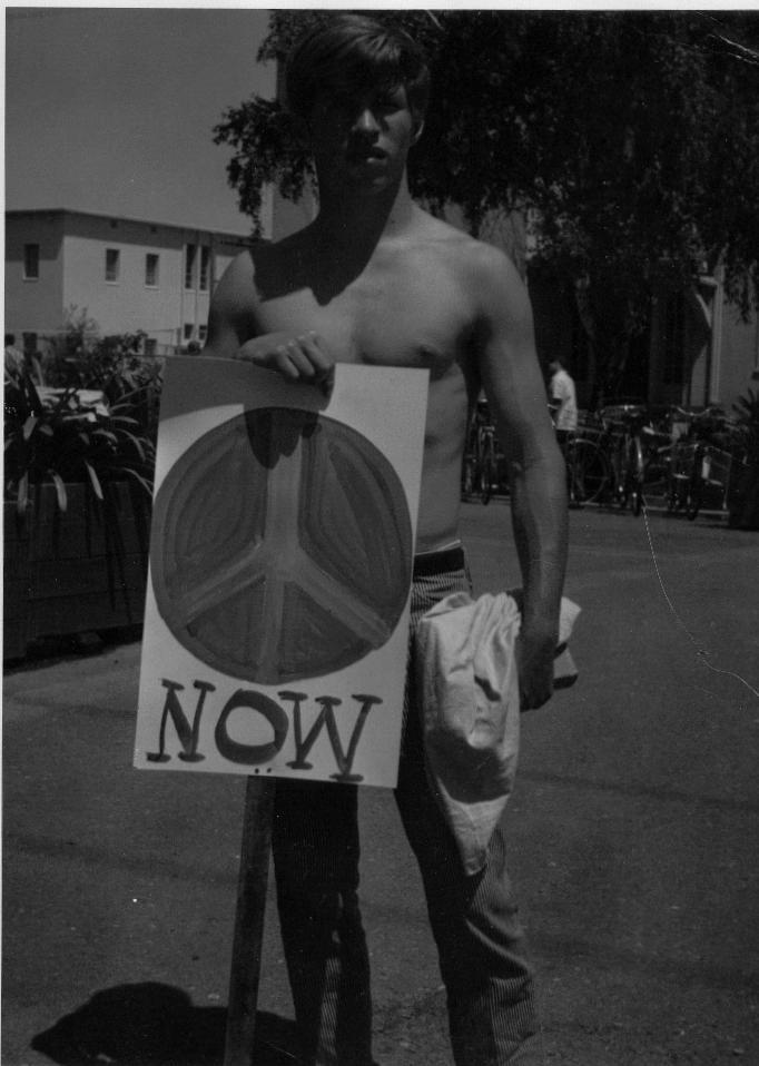 Vietnam War protester holding a sign demanding peace now.