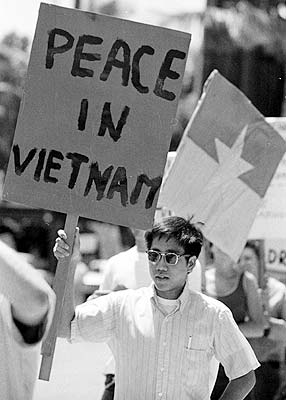 Vietnam War protester holding a sign that reads "Peace in Vietnam."