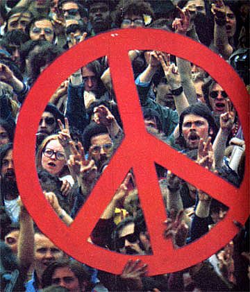 Large crowd of Vietnam War protester holding a large, red peace sign.