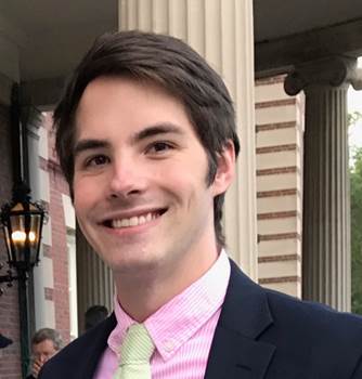 A person wearing a suit and tie smiling at the camera

Description automatically generated
