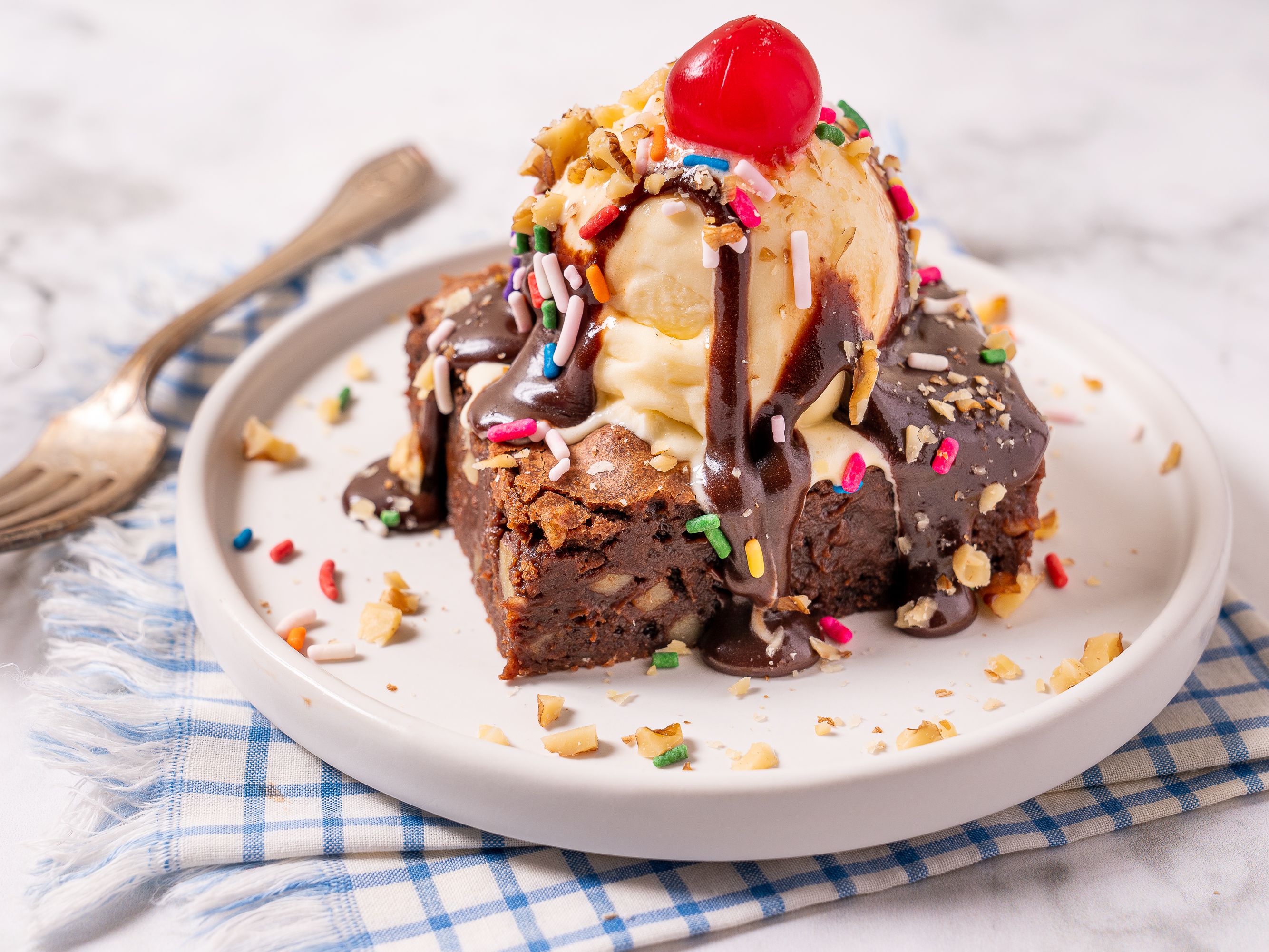 Brownie sundae with a cherry on top in a plate